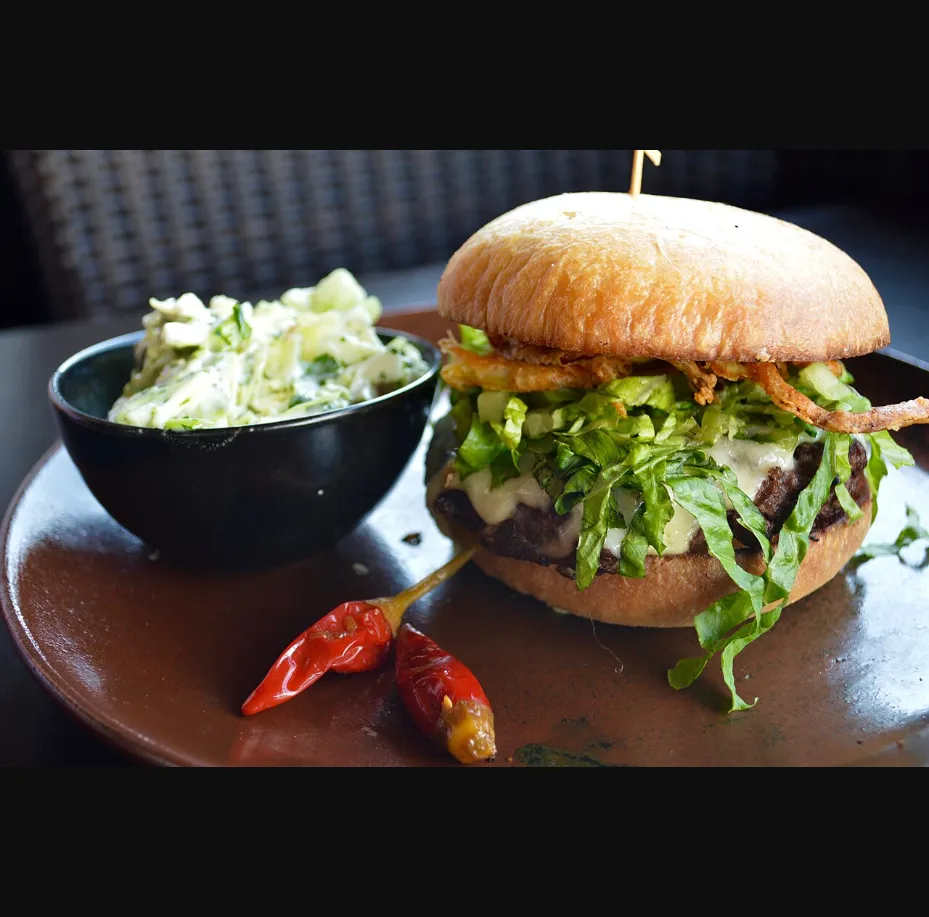 Gourmet burger with roasted peppers at Mariposa Latin Inspired Grill